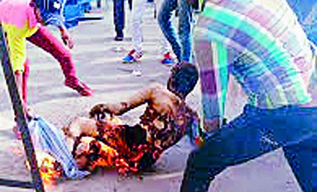 People try to douse the fire engulfing Congress worker Muni Koti Reddy who set himself ablaze seeking special status for Andhra Pradesh at a meet organised by the Congress in Tirupati on Saturday. (Photo: DC) People try to douse the fire engulfing Congress worker Muni Koti Reddy who set himself ablaze seeking special status for Andhra Pradesh at a meet organised by the Congress in Tirupati on Saturday. (Photo: DC)