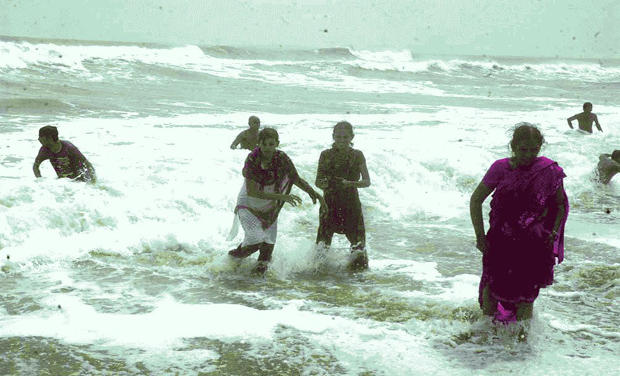 Visitors run out of fear as they watch a huge tidal wave caused by Hudhud at around 11.30 am in Kodur beach in Nellore district on Sunday. (Photo: DC) Visitors run out of fear as they watch a huge tidal wave caused by Hudhud at around 11.30 am in Kodur beach in Nellore district on Sunday. (Photo: DC)