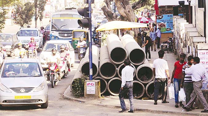 BWSSB has stocked big pipes on the footpath from Wind Tunnel road-ISRO junction to traffic junction near HAL Police Station on Old Airport Road, affecting the movement of pedestrians. (Photo: R. Samuel) BWSSB has stocked big pipes on the footpath from Wind Tunnel road-ISRO junction to traffic junction near HAL Police Station on Old Airport Road, affecting the movement of pedestrians. (Photo: R. Samuel)