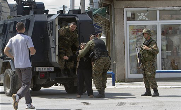 An elderly woman is evacuated safely as the fighting resumes for second day involving the police and an armed group, in northern Macedonian town of Kumanovo. (Photo: AP) An elderly woman is evacuated safely as the fighting resumes for second day involving the police and an armed group, in northern Macedonian town of Kumanovo. (Photo: AP)