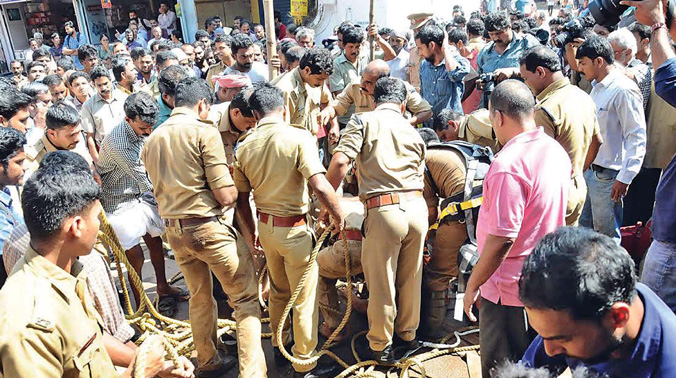 Fire and safety personnel try to pull out Noushad and the two labourers stuck in the sewer near Jaya auditorium in Kozhikode. (Photo: DC FILE) Fire and safety personnel try to pull out Noushad and the two labourers stuck in the sewer near Jaya auditorium in Kozhikode. (Photo: DC FILE)