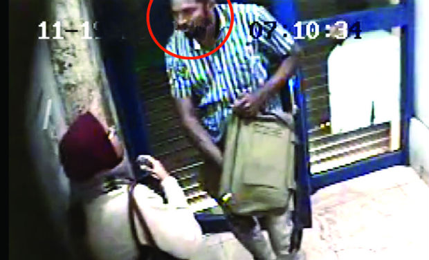 A CCTV image of the attacker reaching for revolver and machete in his bag at an ATM in Bengaluru. A CCTV image of the attacker reaching for revolver and machete in his bag at an ATM in Bengaluru.