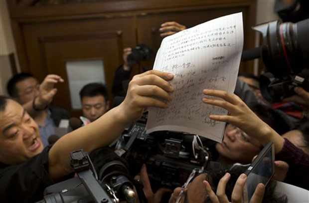 A Chinese relative of the passengers aboard the missing Malaysia Airlines plane passes a demand letter for the airlines, signed by other relatives, to the media at a hotel, in Beijing. Photo- AP A Chinese relative of the passengers aboard the missing Malaysia Airlines plane passes a demand letter for the airlines, signed by other relatives, to the media at a hotel, in Beijing. Photo- AP