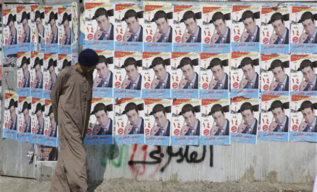 An Egyptian walks in front of posters of a parliamentary candidate in Giza, just outside of Cairo. (Photo: AP) An Egyptian walks in front of posters of a parliamentary candidate in Giza, just outside of Cairo. (Photo: AP)