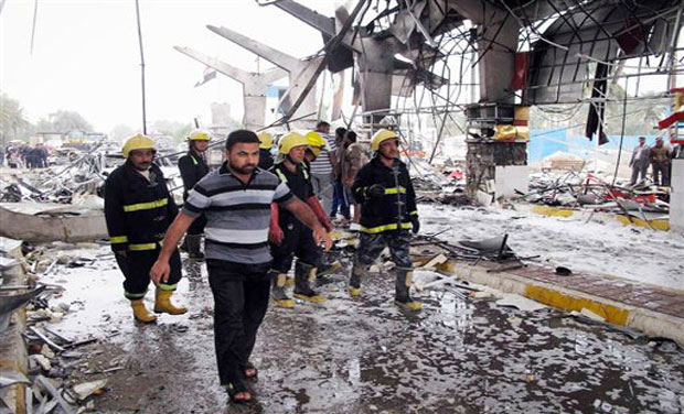 Fire fighters and civilians inspect the site of a massive bomb attack in Hillah, about 60 miles (95 kilometers) south of Baghdad, Iraq. Photo- AP Fire fighters and civilians inspect the site of a massive bomb attack in Hillah, about 60 miles (95 kilometers) south of Baghdad, Iraq. Photo- AP