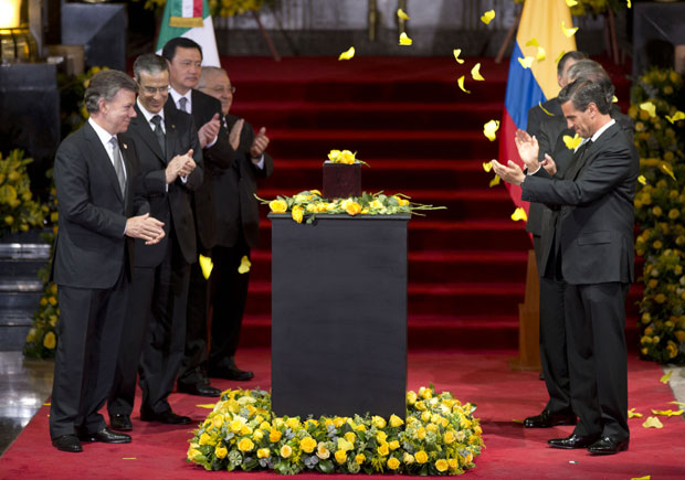 Columbia's President Juan Manuel Santos, left, and Mexico's President Enrique Pena Nieto, right, applaud as yellow paper butterflies fall, next to the urn containing the ashes of Colombian Nobel Literature laureate Gabriel Garcia Marquez during the Columbia's President Juan Manuel Santos, left, and Mexico's President Enrique Pena Nieto, right, applaud as yellow paper butterflies fall, next to the urn containing the ashes of Colombian Nobel Literature laureate Gabriel Garcia Marquez during the