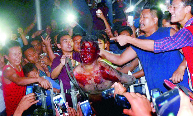 Protesters beat an accused, centre, of raping a woman after being dragged out of district jail in Dimapur, Nagaland on Thursday. (Photo: PTI) Protesters beat an accused, centre, of raping a woman after being dragged out of district jail in Dimapur, Nagaland on Thursday. (Photo: PTI)