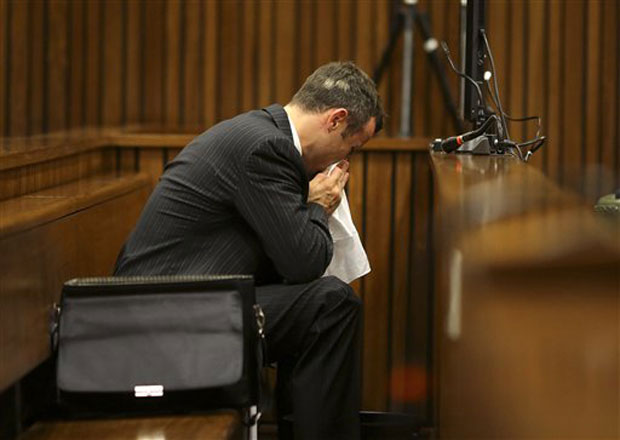 Oscar Pistorius blows his nose after reaching for a bucket as he listened to cross questioning about the events surrounding the shooting death of his girlfriend Reeva Steenkamp on Monday. Photo- AP Oscar Pistorius blows his nose after reaching for a bucket as he listened to cross questioning about the events surrounding the shooting death of his girlfriend Reeva Steenkamp on Monday. Photo- AP