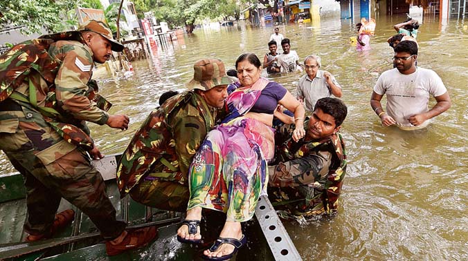 Army personnel rescue a woman from a flooded locality in rain-hit Chennai (Photo: PTI) Army personnel rescue a woman from a flooded locality in rain-hit Chennai (Photo: PTI)
