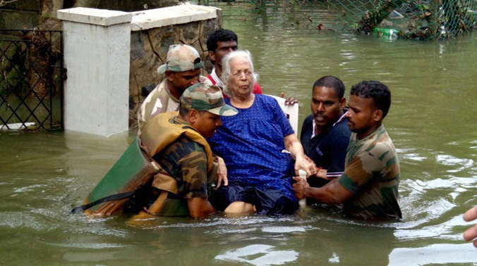 Army personnel carrying an elderly woman to safe place during their rescue operation in flood affected Chennai. (Photo: PTI) Army personnel carrying an elderly woman to safe place during their rescue operation in flood affected Chennai. (Photo: PTI)
