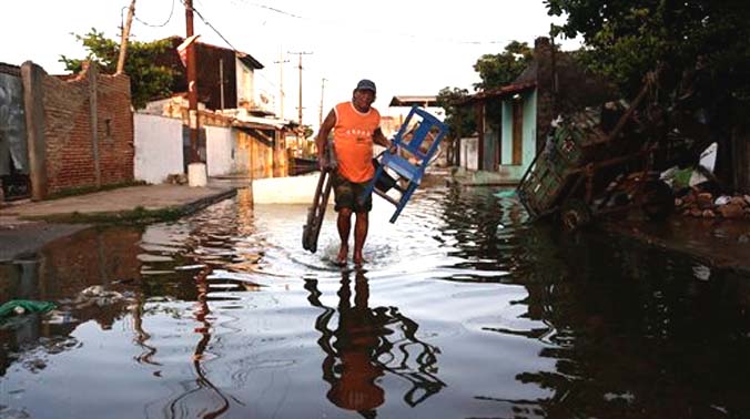 A man carries chairs from his flooded home to a shelter in Asuncion, Paraguay. (Photo: AP) A man carries chairs from his flooded home to a shelter in Asuncion, Paraguay. (Photo: AP)
