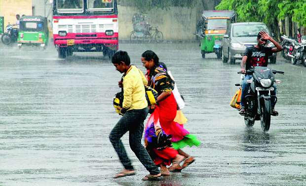 Pedestrians cross a road in Vijayawada as it rains on Sunday. (Photo: DC) Pedestrians cross a road in Vijayawada as it rains on Sunday. (Photo: DC)