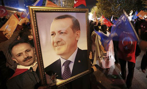 A supporter of the Justice and Development Party, (AKP), holds a portrait of Turkey's President Recep Tayyip Erdogan as people celebrate outside the AKP headquarters, in Istanbul. (Photo: AP) A supporter of the Justice and Development Party, (AKP), holds a portrait of Turkey's President Recep Tayyip Erdogan as people celebrate outside the AKP headquarters, in Istanbul. (Photo: AP)