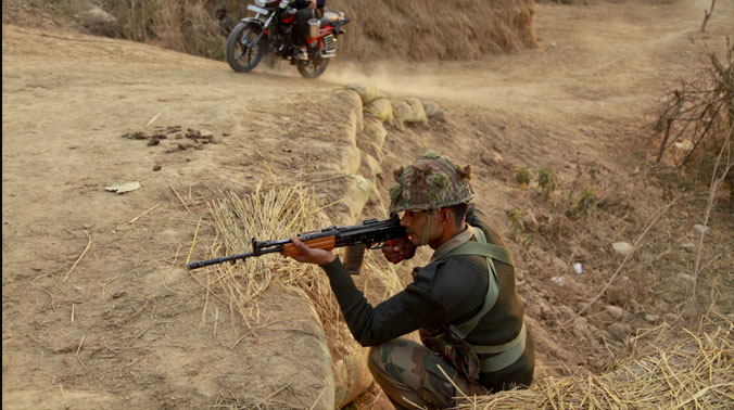 An Indian civilian rides past as an army soldier takes position outside the Indian air force base in Pathankot (Photo: PTI) An Indian civilian rides past as an army soldier takes position outside the Indian air force base in Pathankot (Photo: PTI)