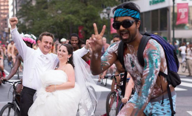Ross Cohen, left, and Blair Delson celebrate their wedding day at the edge of Dilworth Plaza in Philadelphia, as participants in the annual Philly Naked Bike Ride pass by. (AP) Ross Cohen, left, and Blair Delson celebrate their wedding day at the edge of Dilworth Plaza in Philadelphia, as participants in the annual Philly Naked Bike Ride pass by. (AP)