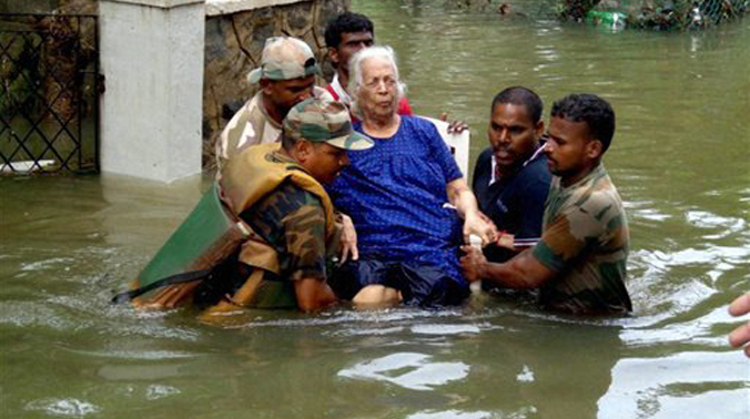 Army personnel carrying an elderly woman to safe place during their rescue operation in flood affected Chennai (Photo: AP) Army personnel carrying an elderly woman to safe place during their rescue operation in flood affected Chennai (Photo: AP)
