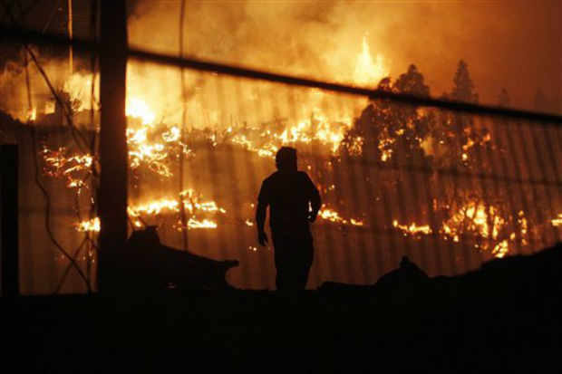 A man walks as an out of control forest fire destroys homes in the city of Valparaiso, Chile, on Sunday. (Photo: AP)
A man walks as an out of control forest fire destroys homes in the city of Valparaiso, Chile, on Sunday. (Photo: AP) 