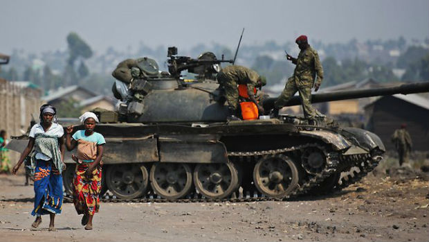Two Congolese women walk past a government army tank on the outskirts of Goma. (Photo: AFP) Two Congolese women walk past a government army tank on the outskirts of Goma. (Photo: AFP)