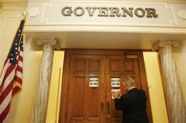 Nathaniel Batchelder, with the Oklahoma Coalition Against the Death Penalty, places a sign protesting the death penalty on Gov. Mary Fallin's office at the state Capitol in Oklahoma City, on Tuesday. (Photo: AP) Nathaniel Batchelder, with the Oklahoma Coalition Against the Death Penalty, places a sign protesting the death penalty on Gov. Mary Fallin's office at the state Capitol in Oklahoma City, on Tuesday. (Photo: AP)