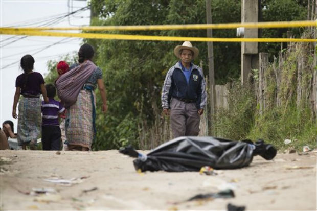 A resident pauses to look at a taped off area, where a body lies wrapped in a black bag, in Pajoques, Guatemala, on Saturday. (Photo: AP)
A resident pauses to look at a taped off area, where a body lies wrapped in a black bag, in Pajoques, Guatemala, on Saturday. (Photo: AP) 