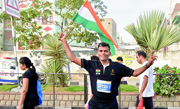 Major Nitin Joshi holds the Indian flag as he runs sideways at the Hyderabad 10k run on Sunday morning. Major Nitin Joshi holds the Indian flag as he runs sideways at the Hyderabad 10k run on Sunday morning.