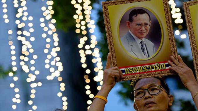 A Thai well-wisher holds a portrait of King Bhumibol Adulyadej as people gather to celebrate his 88th birthday at the Siriraj hospital where the King has been staying for months in Bangkok (Photo: AFP) A Thai well-wisher holds a portrait of King Bhumibol Adulyadej as people gather to celebrate his 88th birthday at the Siriraj hospital where the King has been staying for months in Bangkok (Photo: AFP)