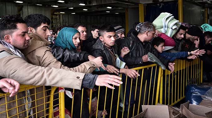Refugees and migrants wait for free blankets and raincoats before disembarking from a government chartered ferry 'El Venizelos' in the port of Piraeus near Athens (Photo: AFP) Refugees and migrants wait for free blankets and raincoats before disembarking from a government chartered ferry 'El Venizelos' in the port of Piraeus near Athens (Photo: AFP)