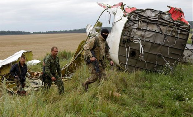 Pro-Russian fighters walk at the site of a crashed Malaysia Airlines passenger plane near the village of Hrabove, Ukraine, eastern Ukraine Friday, July 18, 2014. Rescue workers, policemen and even off-duty coal miners were combing a sprawling area Pro-Russian fighters walk at the site of a crashed Malaysia Airlines passenger plane near the village of Hrabove, Ukraine, eastern Ukraine Friday, July 18, 2014. Rescue workers, policemen and even off-duty coal miners were combing a sprawling area