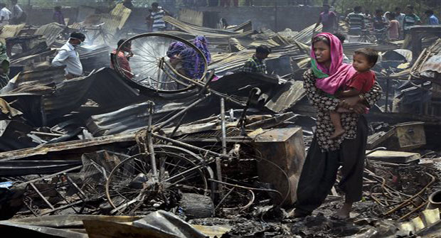 An Indian woman carries a child after their home was destroyed in a fire in New Delhi, India, Friday, April 25, 2014. (Photo: AP) An Indian woman carries a child after their home was destroyed in a fire in New Delhi, India, Friday, April 25, 2014. (Photo: AP)