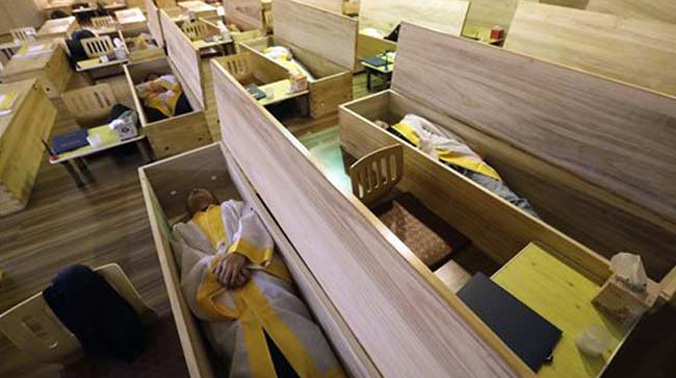 Many who join the mock funerals dressed in shrouds lie down inside wooden coffins to seek relief from the stresses of modern life in South Korea. (Photo: AP) Many who join the mock funerals dressed in shrouds lie down inside wooden coffins to seek relief from the stresses of modern life in South Korea. (Photo: AP)