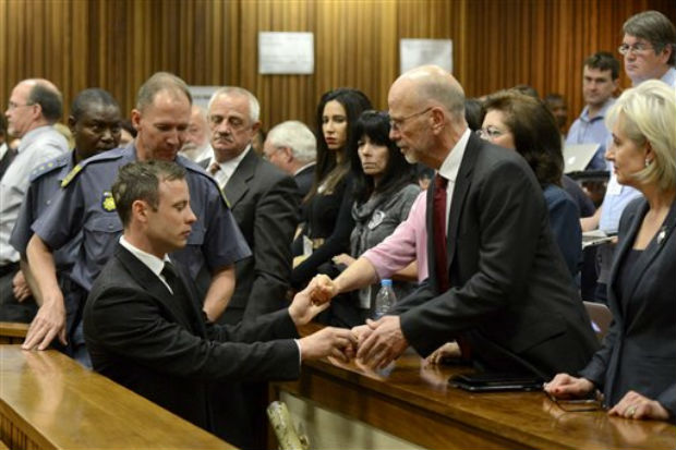 Oscar Pistorius, left front, greets his uncle Arnold Pistorius, right, and other family members as he is led out of court in Pretoria, South Africa. (Photo: AP) Oscar Pistorius, left front, greets his uncle Arnold Pistorius, right, and other family members as he is led out of court in Pretoria, South Africa. (Photo: AP)