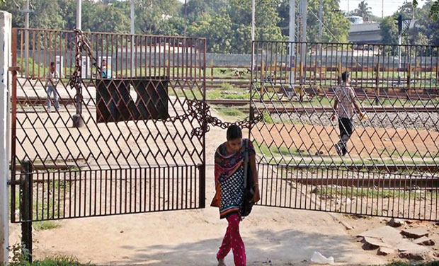 A girl squeezes through the closed gate near the railway mail service office at Tambaram railway station on Thursday. A girl squeezes through the closed gate near the railway mail service office at Tambaram railway station on Thursday.