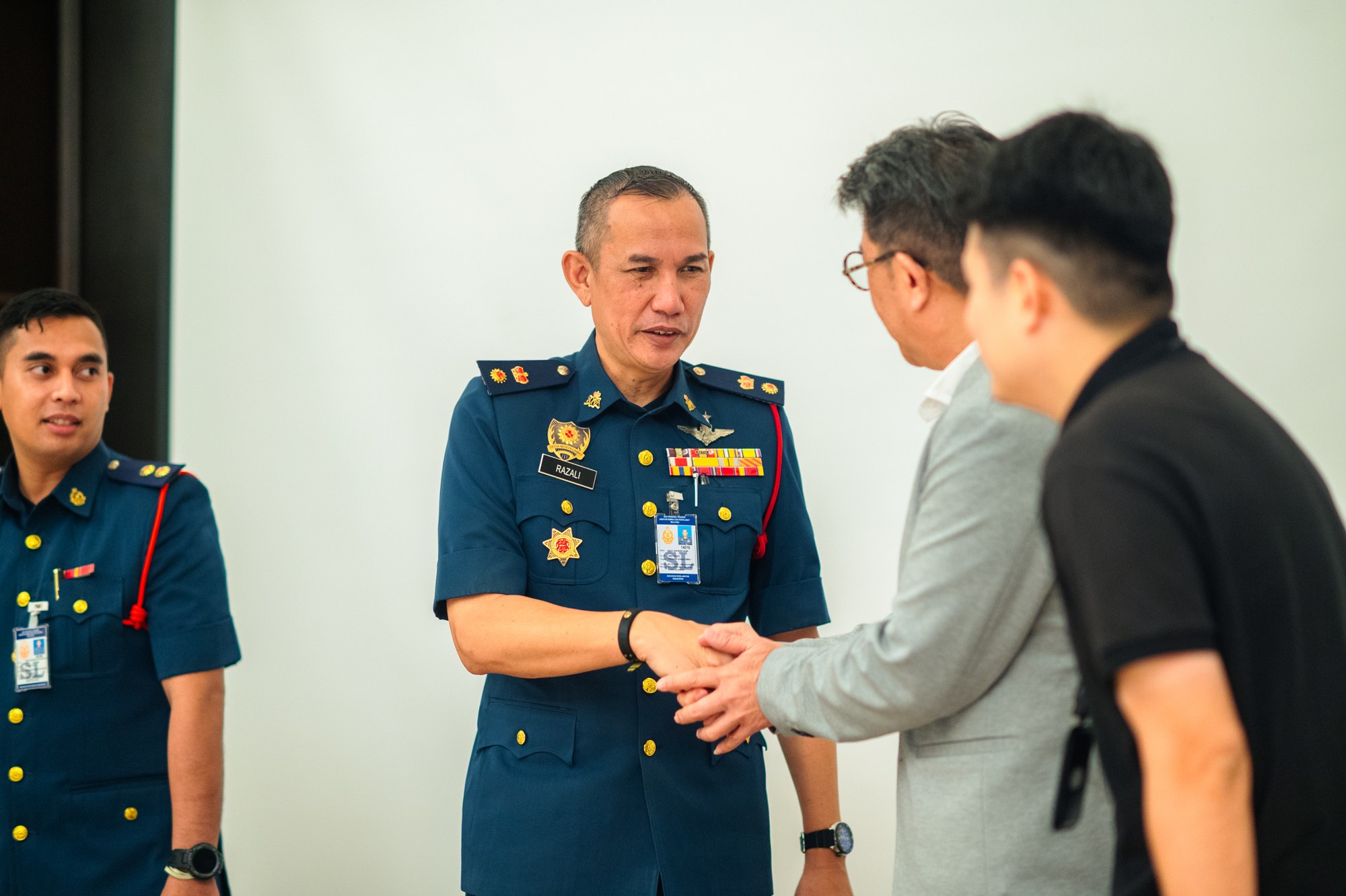 Officer from the Fire and Rescue Department of Malaysia shaking hands with a guest after the BESS safety guidelines session