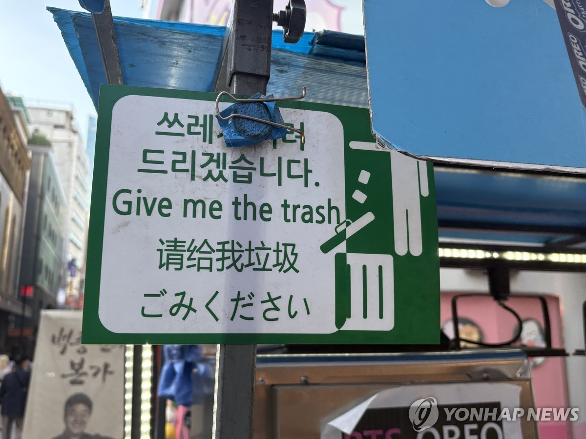 명동거리의 노점상 매대에 붙어있는 '쓰레기 버려드리겠습니다' 안내문