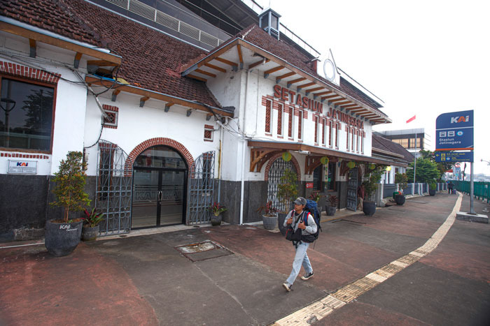 Traveler walks across the old building of Jatinegara Station