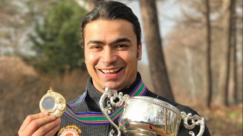 Shiva Keshavan poses with the Asian Luge Championship gold medal and trophy in Nagano, Japan.