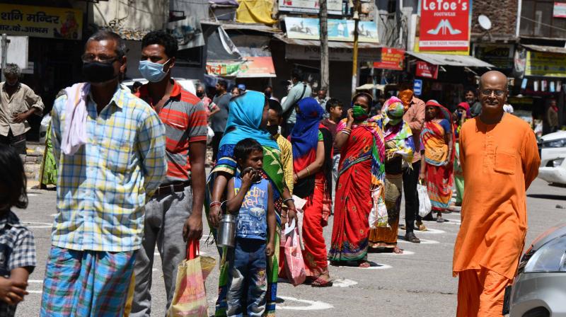 Displaced workers follow social distance guidelines as they line up to receive food served by an NGO during the ongoing nationwide lockdown in New Delhi on April 3,2020. (DC Photo: Pritam Bandyopadhyay)