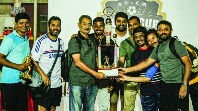 The victorious Our Lady of Health Parish veterans team proudly pose with the Orlem Super Cup, along with Steven Dias, a former India striker.