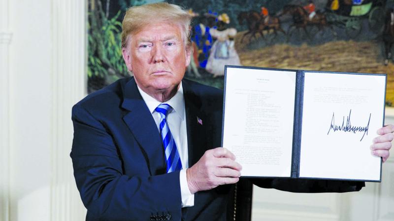 US President Donald Trump shows a signed Presidential Memorandum after delivering a statement on the Iran nuclear deal from the Diplomatic Reception Room of the White House on May 8. (Photo: AP)