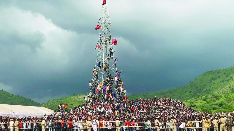 Locals climb a tower to get a glimpse of Prime Minister Narendra Modis helicopter in Udaipur. (Photo: PTI)