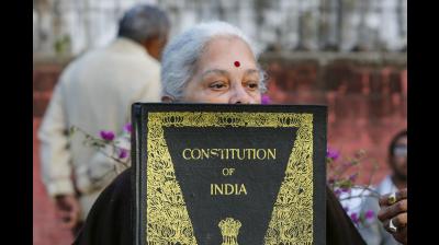 An aged-woman holds a copy of the Indian constitution during a protest against Citizenship (Amendment) Act, outside Gandhi ashram in Ahmedabad. (PTI file Photo)