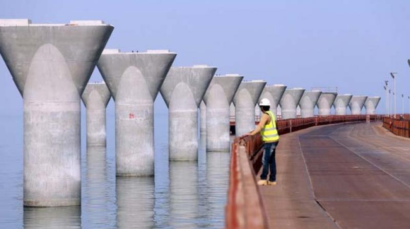 A labourer standing at a construction site in Kuwait City of the Sheikh Jaber Al-Ahmad Al-Sabah causeway.