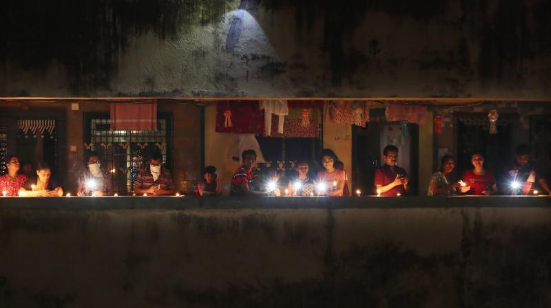 People light candles and switch on torches as instructed by prime minister Narendra Modi at 9 pm on Sunday, April 5, 2020 to mark the countrys fight against the Covid-19 pandemic. (AP) People light candles and switch on torches as instructed by prime minister Narendra Modi at 9 pm on Sunday, April 5, 2020 to mark the countrys fight against the Covid-19 pandemic. (AP)