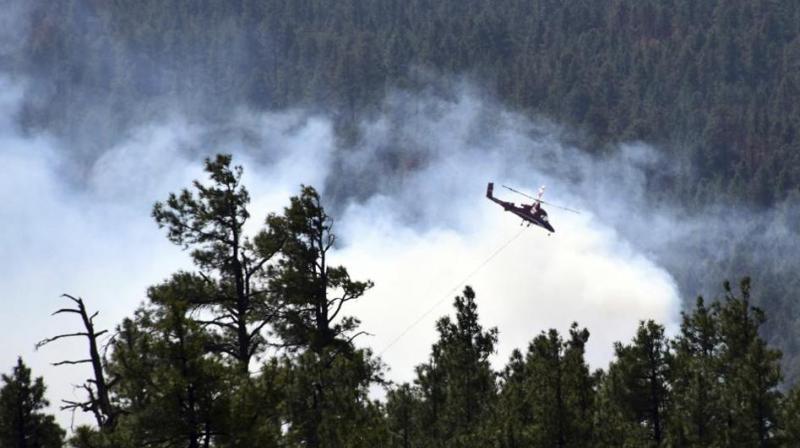 Cooler and damper weather aided firefighters this week but temperatures are expected to rise this weekend. (Photo: AP)