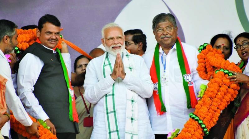 Prime Minister Narendra Modi, flanked by Maharashtra CM Devendra Fadnavis and state BJP president Chandrakant Patil, in Nashik on Thursday. (Photo: ASIAN AGE)