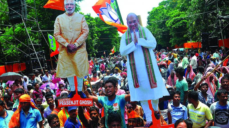 BJP supporters with the cut out of PM Narendra Modi and BJP president Amit Shah during party meeting at Mayo road on Saturday. (Photo: Abhijit Mukherjee)