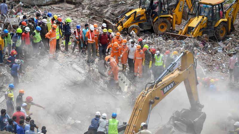 Rescue personnel sift through the rubble in search of survivors at the site where a five-storey apartment building collapsed, at Mahad in Raigad district. (PTI)