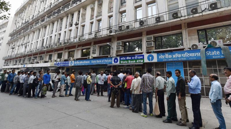 People queue up at out side of banks ATM to get money in New Delhi. (Photo: PTI)
