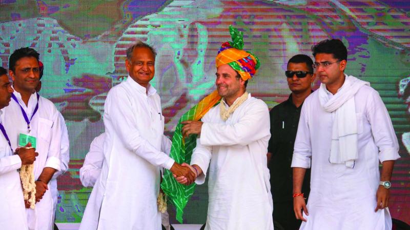 Congress chief Rahul Gandhi shakes hands with Rajasthan chief minister Ashok Gehlot as deputy chief minister Sachin Pilot looks on during an election campaign rally at Bandanwara in Ajmer on Thursday. (Photo: PTI)