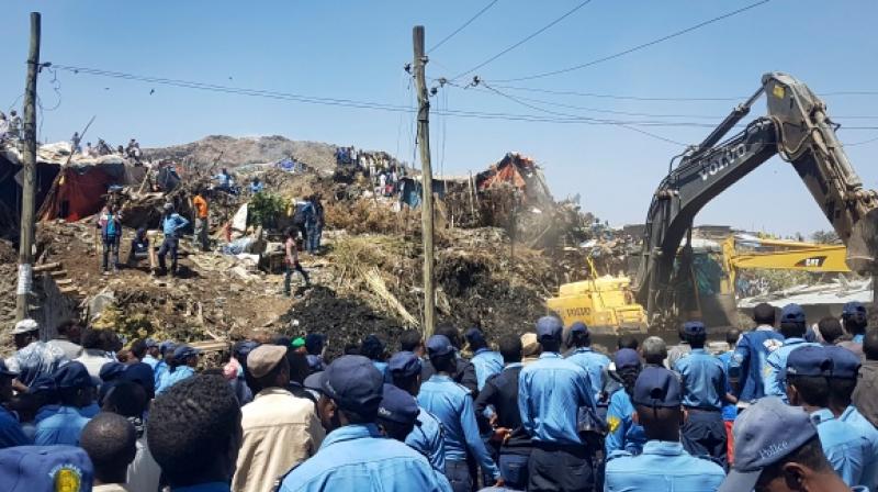 Police officers are seen at the scene of a garbage landslide